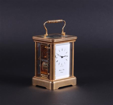 A brass travel clock with enamel dial with Roman numerals and strike on bell....