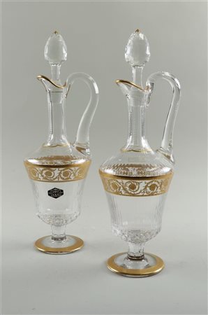 Two crystal decanters on foot, with gilded accents, Saint Louis Paris.H. 40 cm.