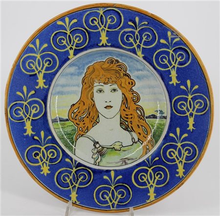 Piatto in ceramica smaltata decorato nel cavetto con figura femminile nello sti