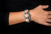 Bracciale rigido in argento rosato con motivi a foglie e medaglioni in corallo rosa