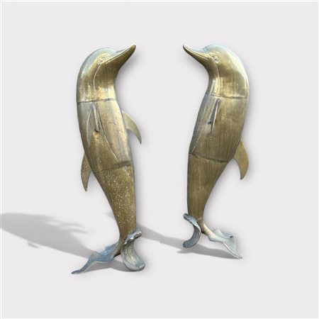 A lot containing two brass pond statues in the shape of dolphins.