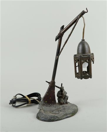 A white metal cold painted lamp in Bergmann style. Shade is damaged.H. 37 cm.