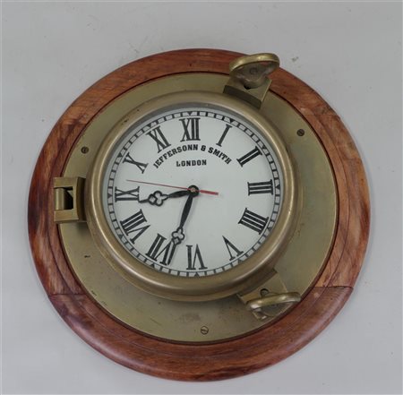 A brass porthole with a (quartz) clock in it.Diam. 40 cm.