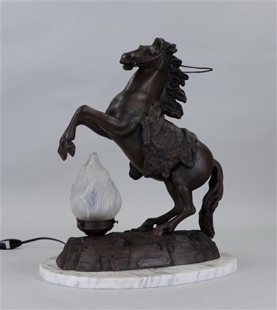 A zamac table lamp in the shape of a rearing horse, on a white marble base.42...