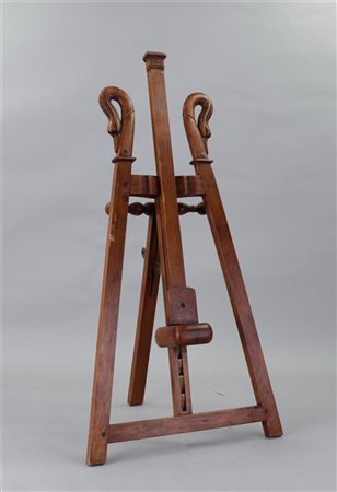 An antique wooden easel, decorated with swan heads.80 x 36 cm.