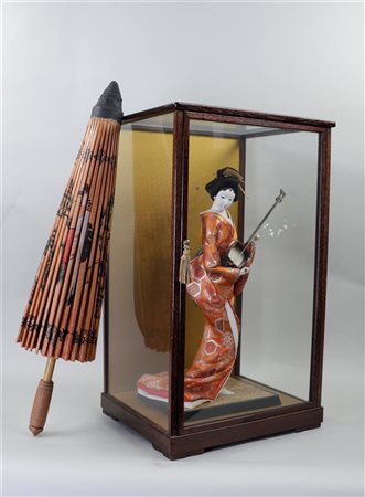 A Japanese Geisha doll in a display case, with a hand-painted paper umbrella.