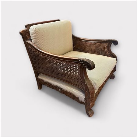 A walnut armchair with carving, and wicker cheeks and back, ca. 1920....