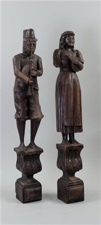 A set of (2) carved statues of a man playing the bagpipes and a woman playing...