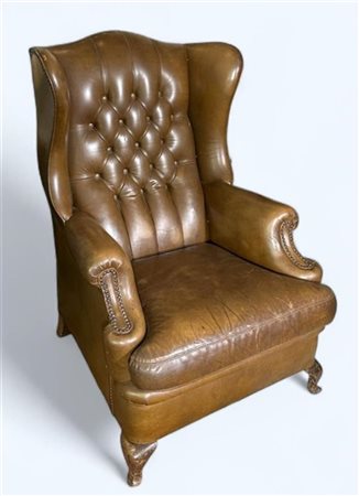 A tufted leather wing chair, Height 110 cm., x Width 75 cm., x Depth 80 cm....