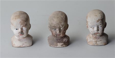 A lot containing (3) painted, biscuit baked doll heads, ca. 1900. H.: 8 cm.