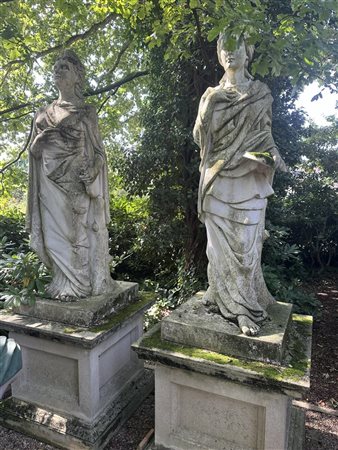 A pair of garden statues on a plinth representing two muses (Musica and...