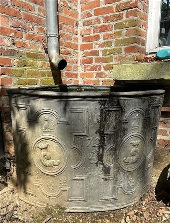 A quarter-round large lead water trough / rain barrel with high relief cast...