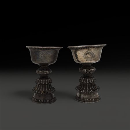 A pair of silver butter lamps