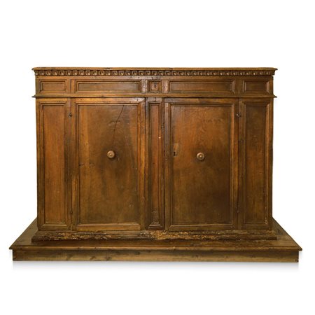 Grande credenza bassa in legno di noce, piano a becco di civetta sottolineato da  dentellatura intagliata, due ante con gangheri cornice alla base, cassetto al sottopiano, due sportelli, fine 18° secolo