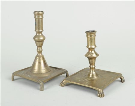 A lot of two Spanish brass candlesticks on a square base and legs, 17th/18th...