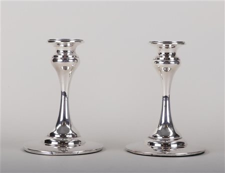 A pair of silver candlesticks, filled. Height 16 cm. Diam.: 11.5 cm. Marked...