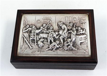 A cigar box with a silver plaque depicting an inn scene in high relief. The...