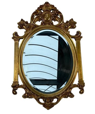 A large faceted oval mirror set in a Louis XVI style frame.H. 75 cm.