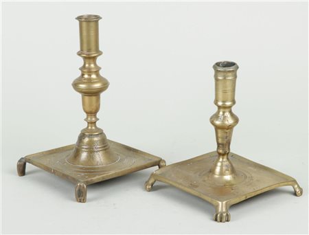 A lot of two Spanish brass candlesticks on a square base and legs, 17th/18th...