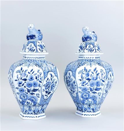 A set of earthenware vases with floral decoration and lions on the lid....