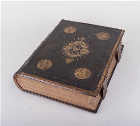 An English Bible bound in leather and edged in brass, with images of Moses,...