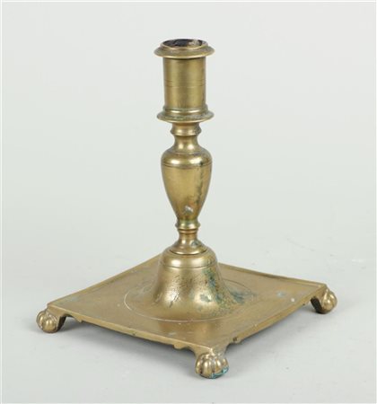 A Spanish brass candlestick on a square base and legs, 17th/18th century.H....