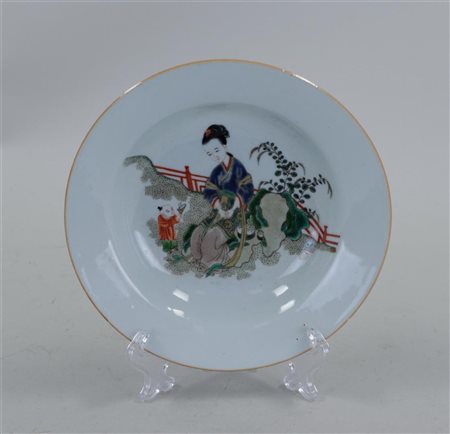 A porcelain famile verte plate decorated with a frame and child. China, 19th...