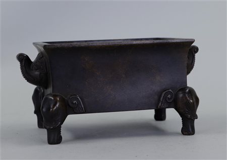 A patinated bronze incense burner standing on elephant heads, marked on the...