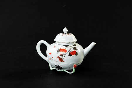 A porcelain teapot with cherry blossoms, bird on branch, lid in lotus shape,...