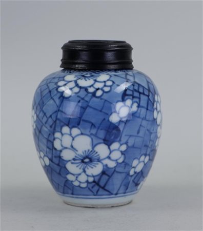 A porcelain ginger jar with prunus decoration and wooden lid. China, 19th...