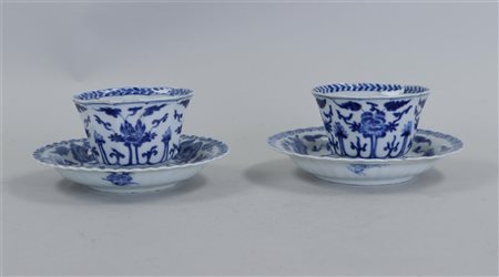 Two porcelain cups and saucers with lotus flowers in the centre and around...