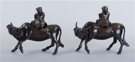 Two bronze figures of water buffalo with boys playing flutes. China, circa...