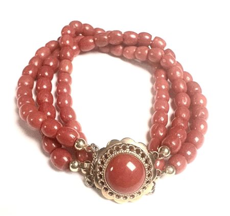 A blood coral bracelet with a beautiful scalloped gold clasp, inlaid with a...