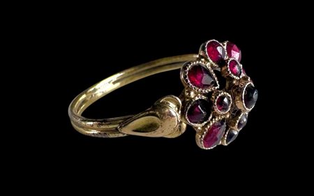 A 14kt yellow gold rosette ring set with garnet. Weight: 2.4 grams Ring size:...