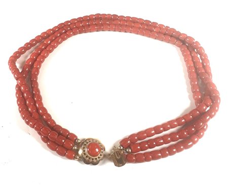 A blood coral necklace with a beautiful scalloped gold clasp, inlaid with a...