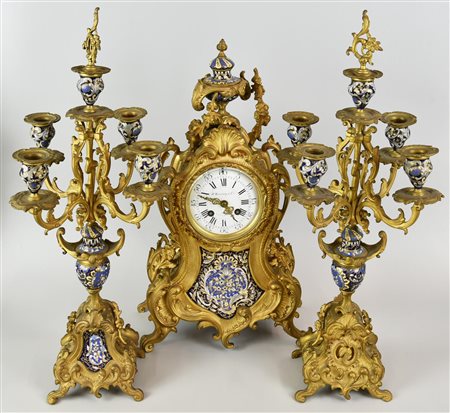 TRITTICO COMPOSTO DA OROLOGIO E DUE CANDELABRI, inizi XX secolo bronzo dorato...