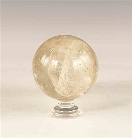 Sfera in cristallo di rocca poggiante su base in plexiglass, h. cm. 12,5 .