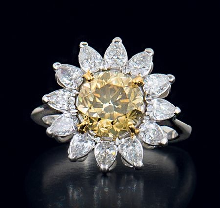 ANELLO ANELLO. In oro bianco 18 kt a fiore con al centro diamante fancy...