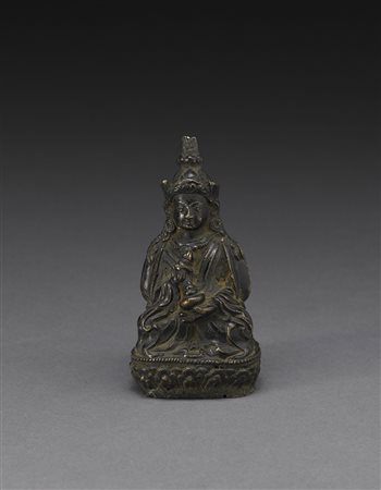 Piccolo Bodhisattva in bronzo, raffigurato seduto su base con petali di loto,...