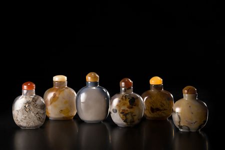 Sei snuff bottles in agata di forma arrotondata e base ovale, con venature di...