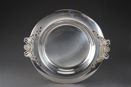 Piatto biansato in argento con anse in rilievo cesellate a cigni e vasi...