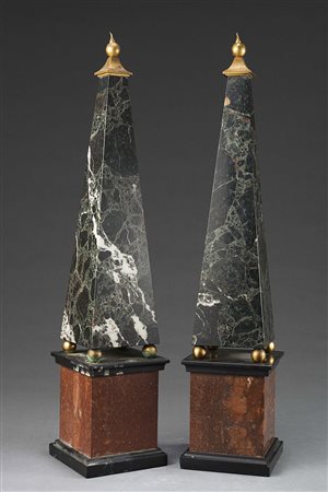 Coppia di obelischi in marmo poggianti su base sorretti da sfere in metallo...