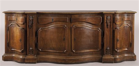 Grande credenza in noce mossa sul fronte a quattro sportelli e quattro...