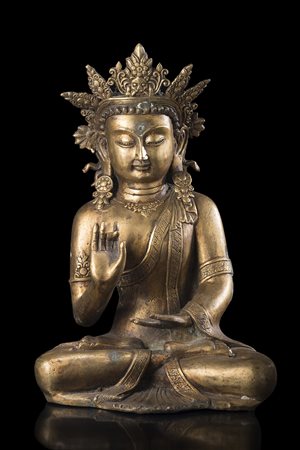 Bodhisattva in bronzo dorato, raffigurato seduto a gambe incrociate, il volto...