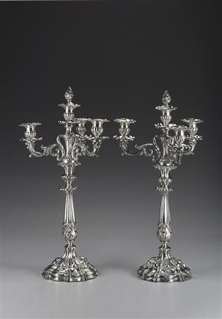 Coppia di candelabri a tre fiamme in argento a base mistilinea decorata a...