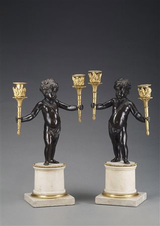 Coppia di candelieri a due fiamme, in bronzo raffiguranti putti che...