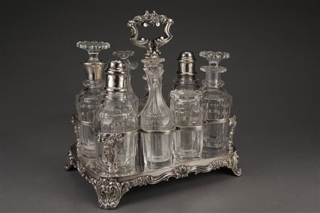 Cruet in metallo argentato con base e montante decorati a volute fogliate,...