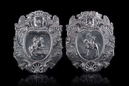 Coppia di appliques in argento con sbalzo centrale raffigurante cavalieri...