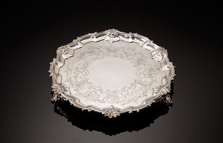 Salver in argento con fondo cesellato a volute fogliate e fiori. Cavetto...