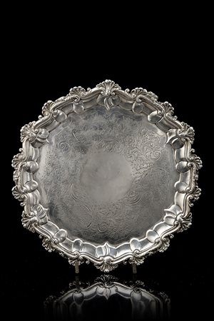 Salver in argento con fondo cesellato a volute fogliate e fiori, cavetto...